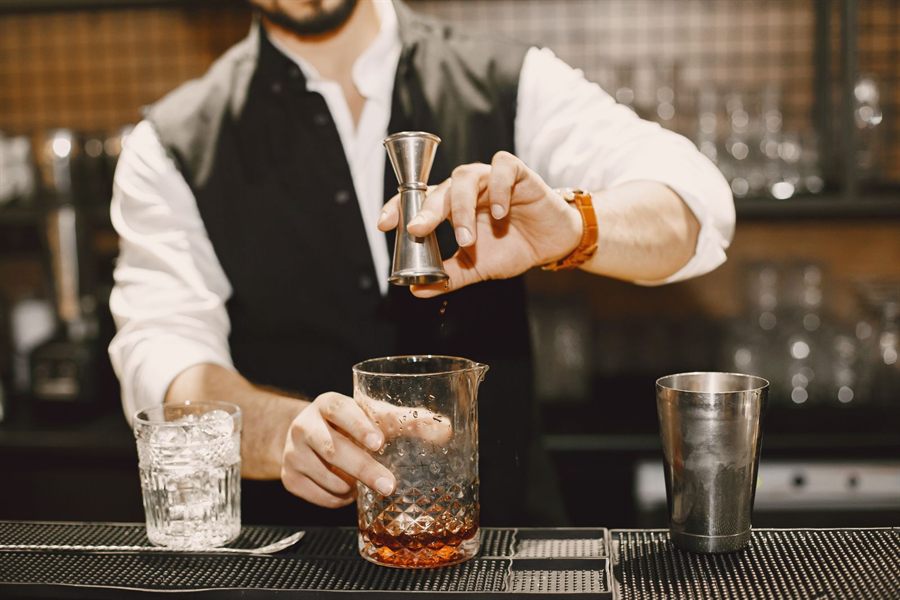 Bartender mixing a cocktail at an elegant bar counter