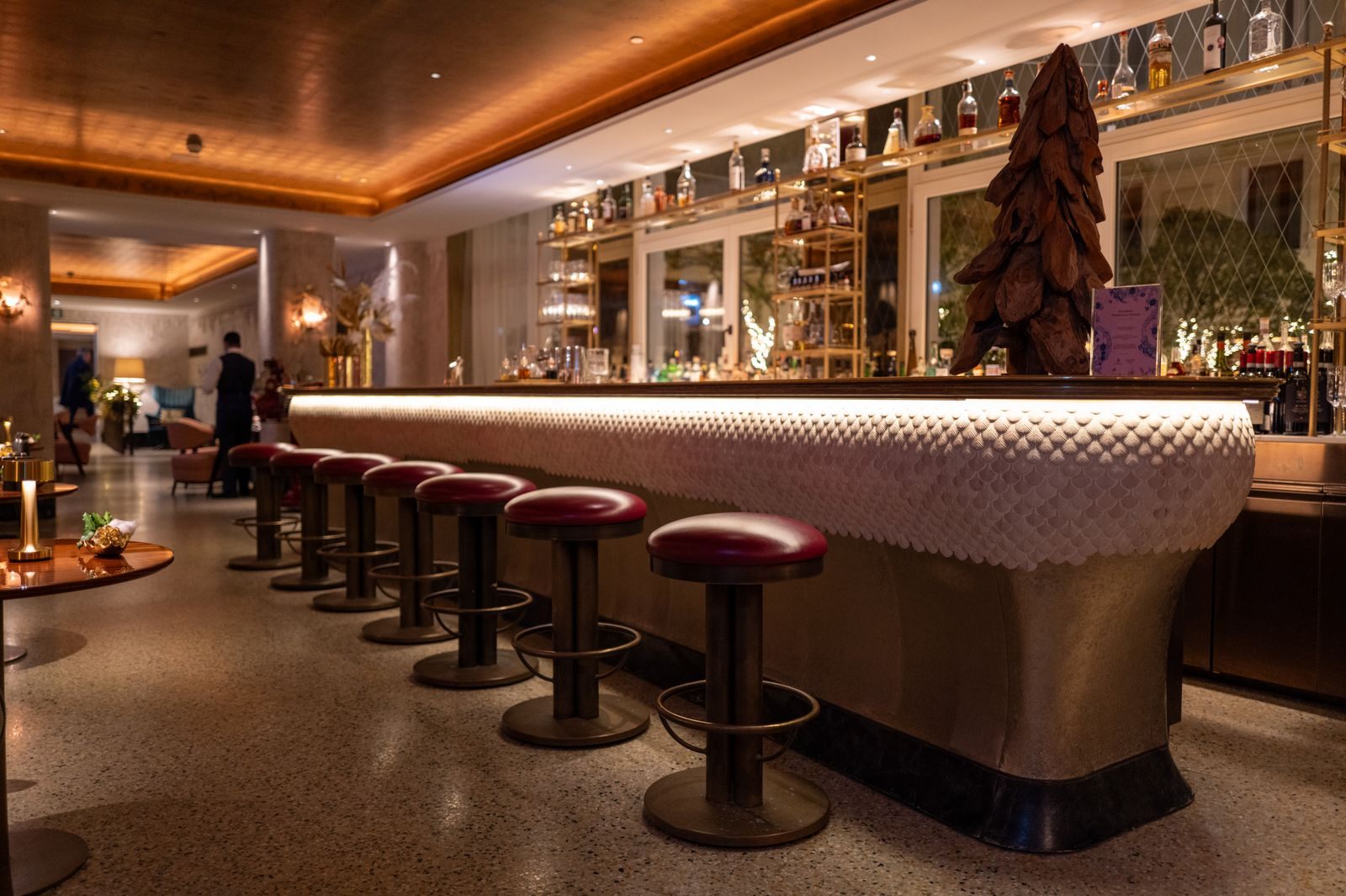Elegant bar with a long counter and stools, the kind of onboard spending the Carnival cruise rewards program counts